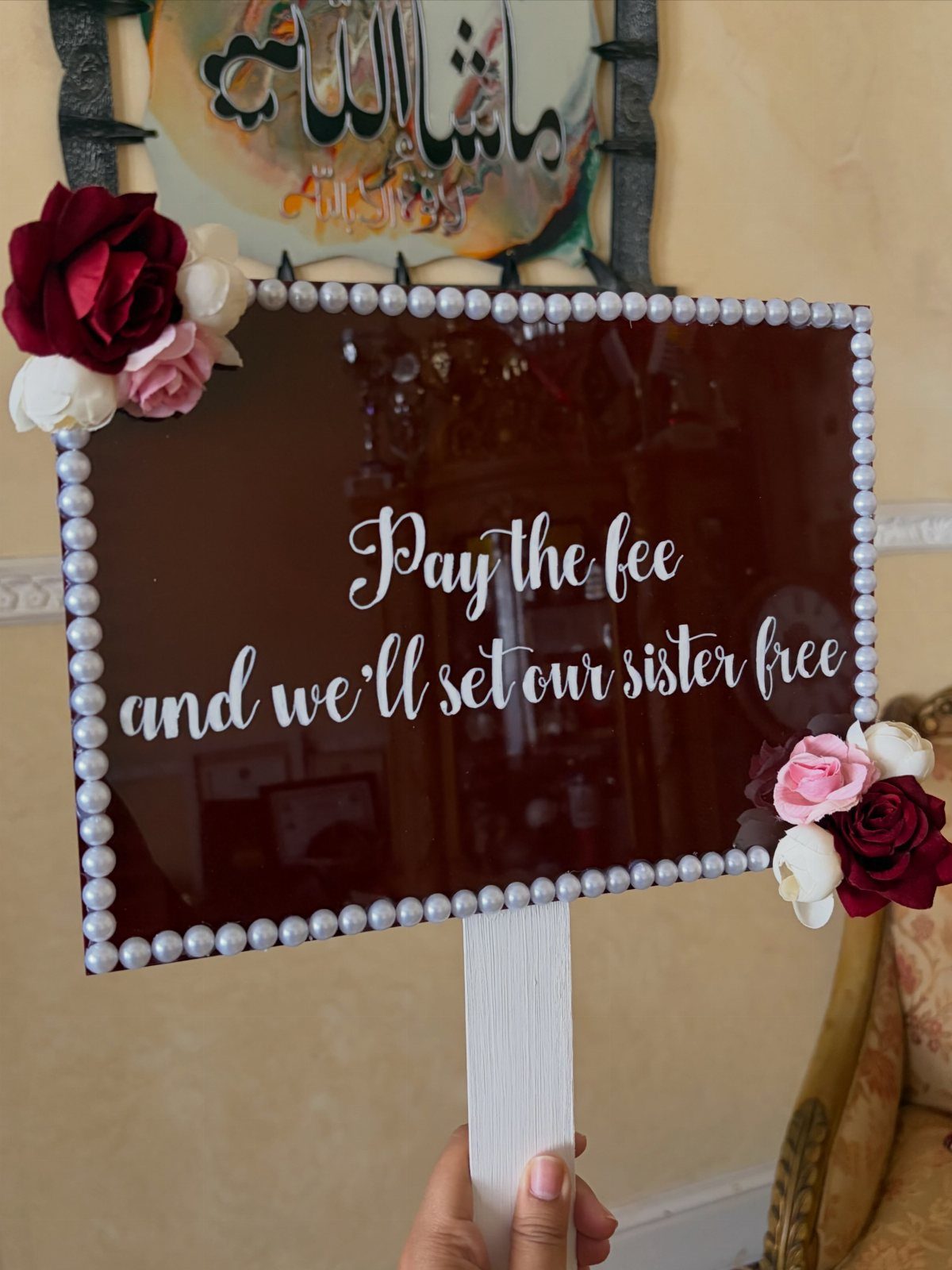 Dark brown wedding sign with pearl border and text about paying a fee.