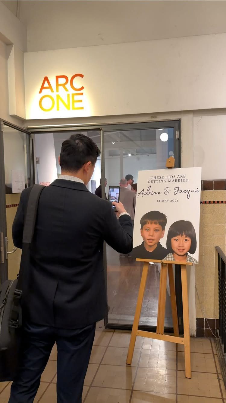 Wedding welcome sign on a wooden easel featuring childhood photos of the couple.