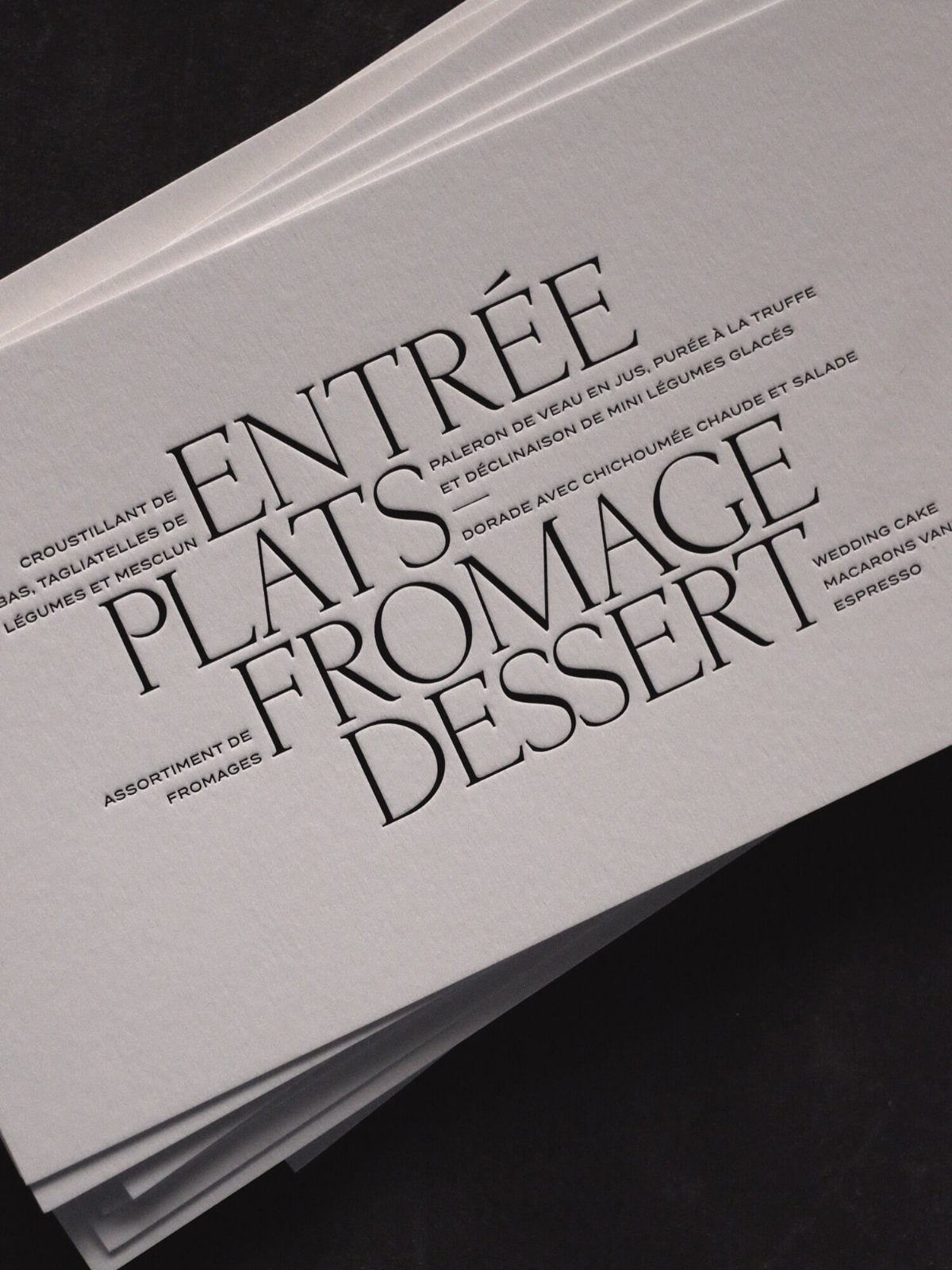 White wedding menu featuring elegant serif typography for course headings and descriptions.