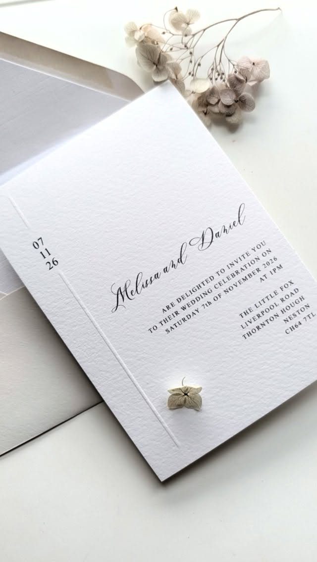 Wedding invitation with elegant script names and serif body text on white paper.