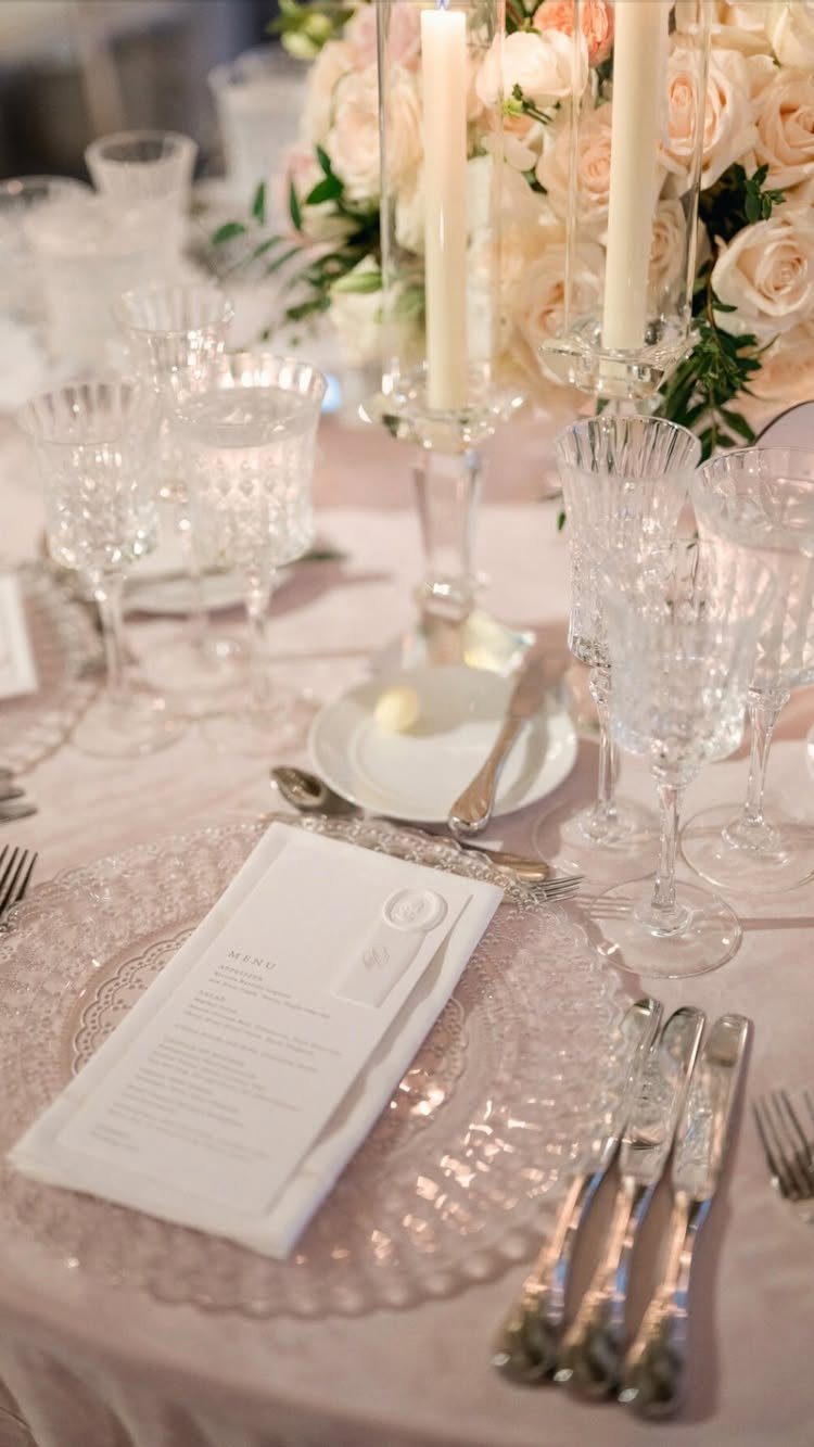 Wedding menu card on a glass plate with elegant table setting and roses