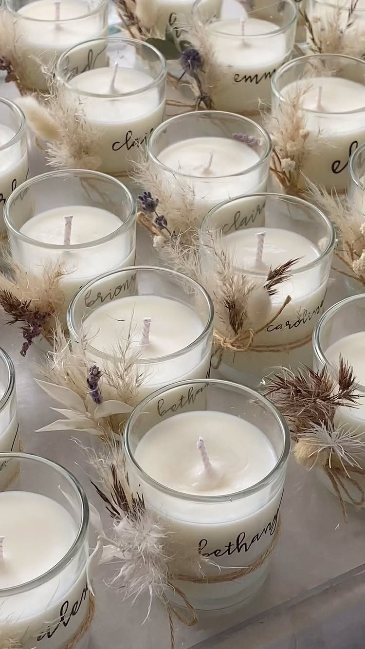 White candles in glass jars decorated with dried lavender and twine ties.