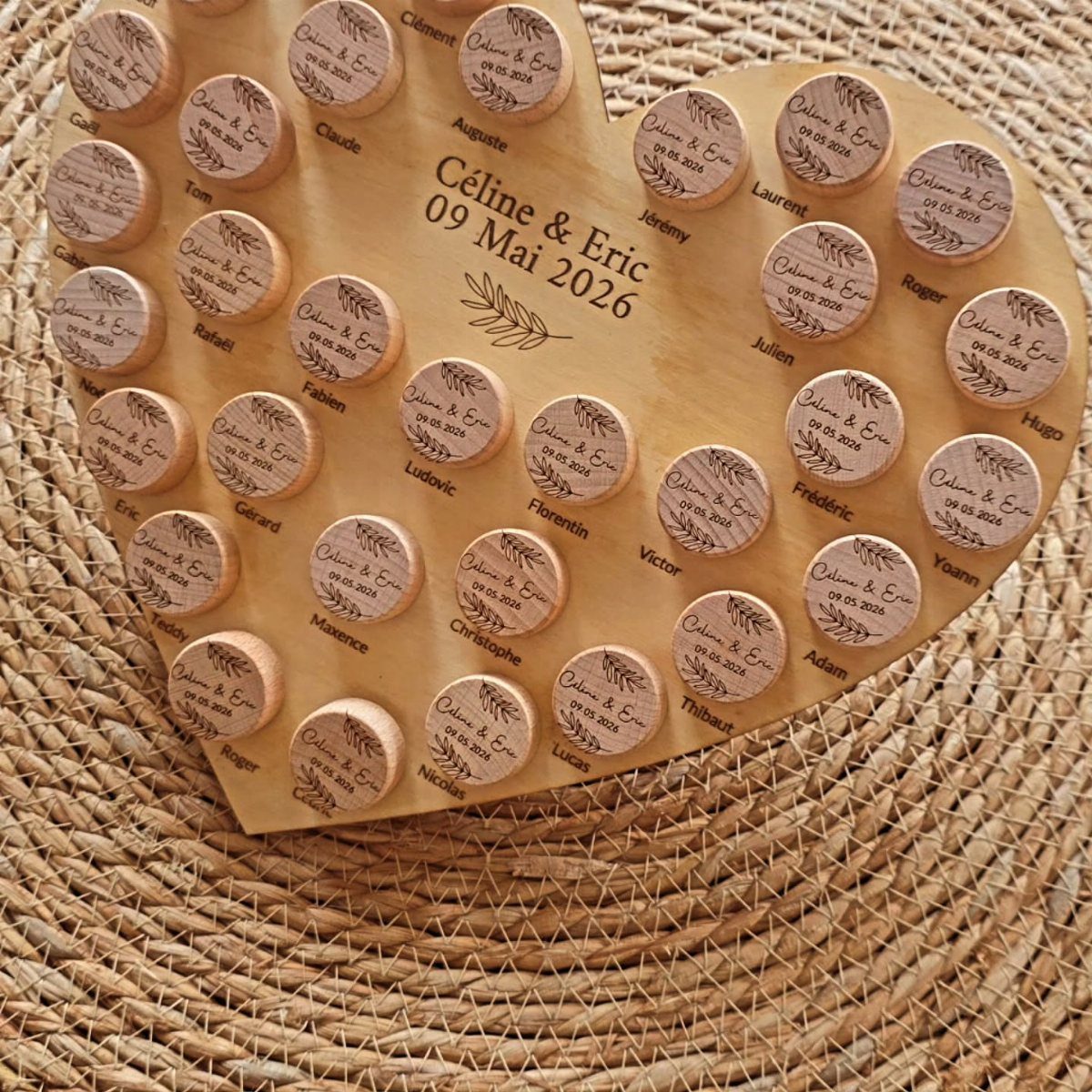 Heart-shaped wooden board with engraved name discs for wedding guest seating or favors.