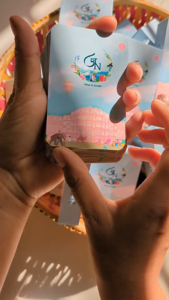 Custom playing cards with blue illustrated covers held in a person's hands.