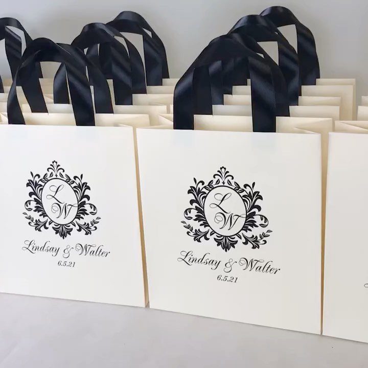 White wedding welcome bags with black ribbon handles and personalized black monogram printing.