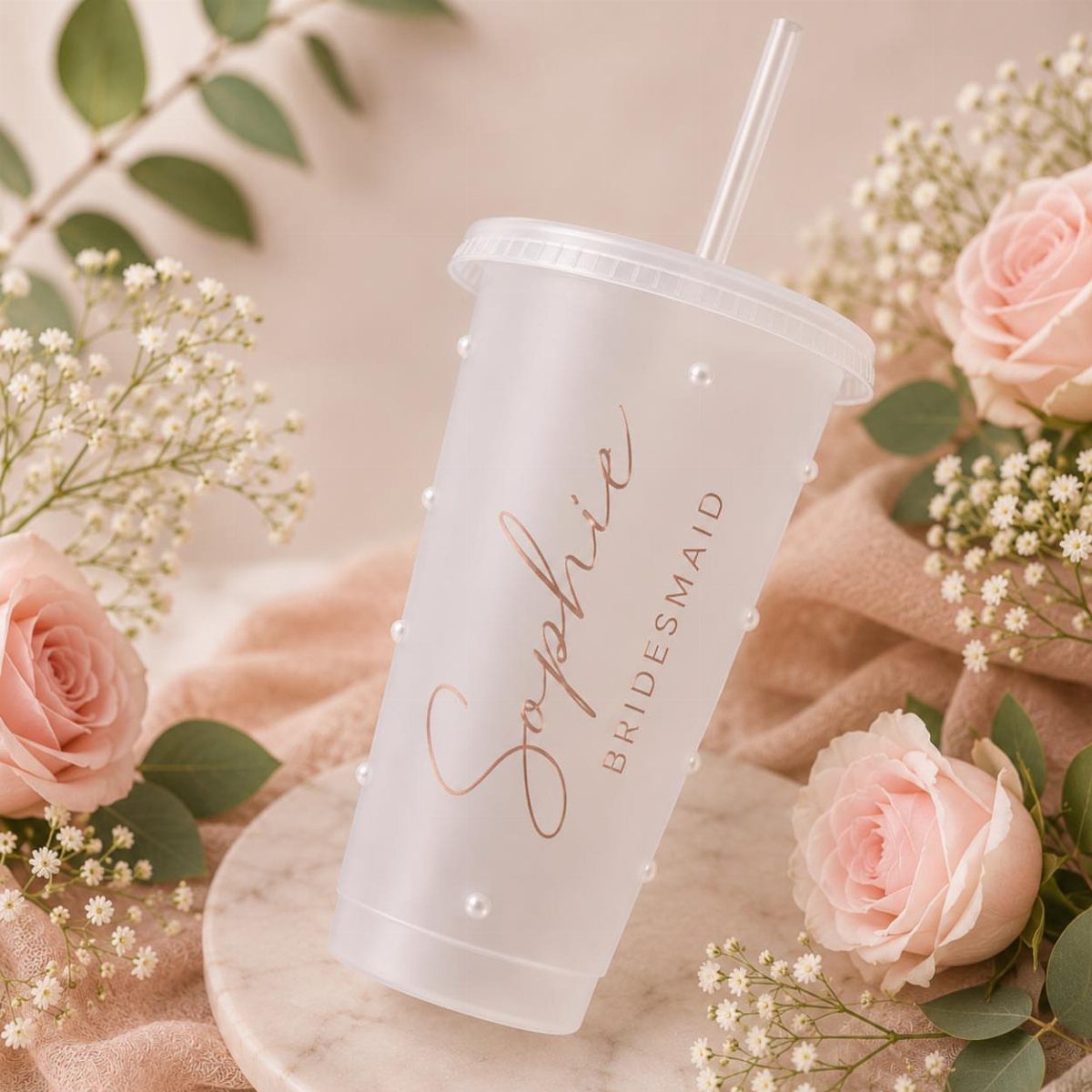 Frosted reusable bridesmaid cup with rose gold lettering surrounded by pink roses